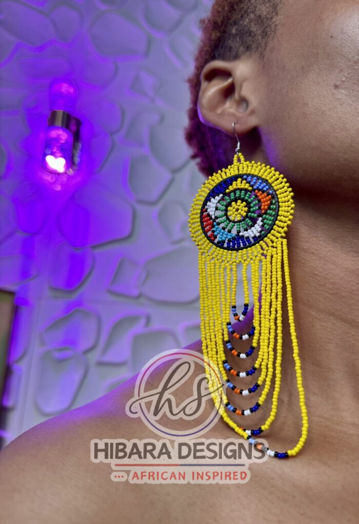 These earrings are traditionally handmade beaded by the Zulu women in South Africa. Nandi Beaded Earrings with Large Circle and beaded drop African Beaded Earrings with multiple colors Large Circle beads cascading down. Nandi Beaded earrings is very lightweight earrings that worn for any occasions. We believe that this piece of earrings is a must in every female jewelries collection. Zulu Beaded Earrings Made from colorful seed beads Earrings are very lightweight Size: 3.5in width earring hook post with rubber earring backs provided